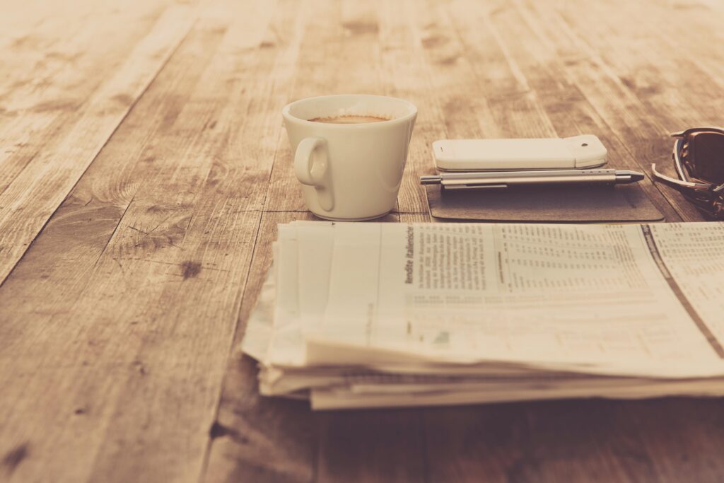 pexels photo 97050 97050 A warm vintage morning setup with coffee, newspaper, and smartphone on wooden table.
